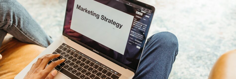 Man with laptop that says marketing strategy