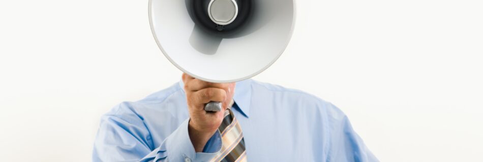 Man wearing tie shouting into megaphone